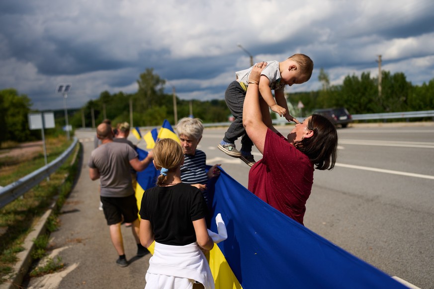 People wait to greet Ukrainian soldiers as they return from captivity after a Prisoners of War (POWs) exchange between Russia and Ukraine, in Chernihiv region, Ukraine, Wednesday, Aug. 19, 2026. (AP P ...
