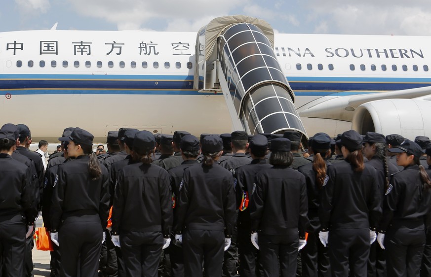 epa06260473 Chinese police officers arrive at the Phnom Penh International Airport, in Phnom Penh, Cambodia, 12 October 2017. Cambodian authorities deported 74 Chinese citizens back to China after the ...