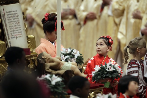 Children walk past a statue of baby Jesus at the end of the Christmas Eve Mass celebrated by Pope Francis in St. Peter&#039;s Basilica at the Vatican, Monday, Dec. 24, 2018. (AP Photo/Alessandra Taran ...