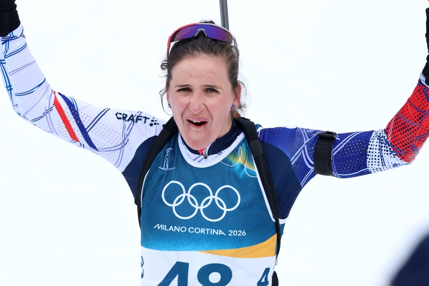 epa12727108 Julia Simon of France celebrates after crossing the finish line in the Women's 15km Individual of the Biathlon competitions at the Milano Cortina 2026 Winter Olympic Games, in Anterse ...