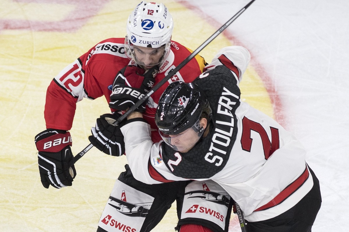epa06316568 Switzerland's Luca Cunti, left, fights for the puck against Canada's Karl Stollery during the 2017 Karjala Cup ice hockey match between Switzerland and Canada in the Tissot Arena ...