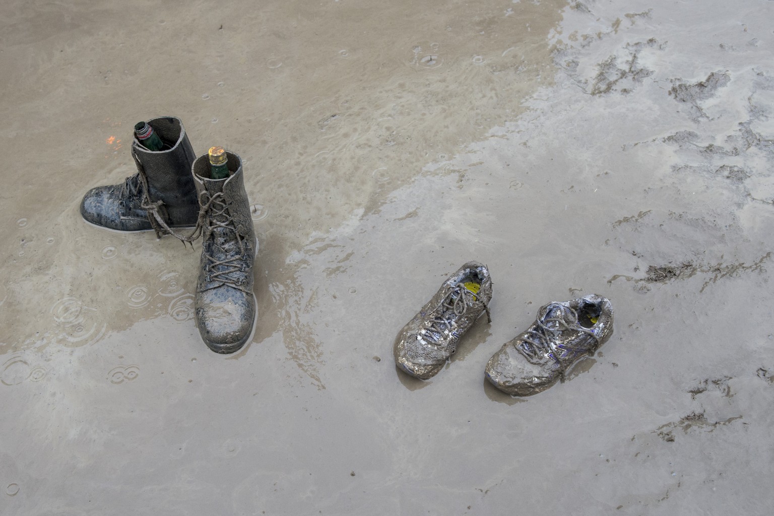 Schuhe liegen im Schlamm am Musikfestival Openair St. Gallen am Sonntag, 29. Juni 2014, im Sittertobel in St. Gallen. (KEYSTONE/Ennio Leanza)