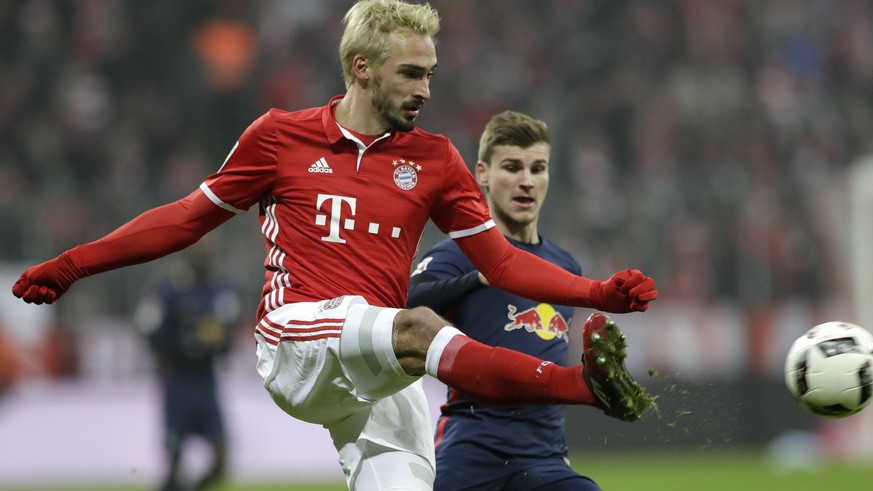 Bayern&#039;s Mats Hummels, foreground, kicks the ball in front of Leipzig&#039;s Timo Werner during the German Bundesliga soccer match between FC Bayern Munich and RB Leipzig at the Allianz Arena sta ...