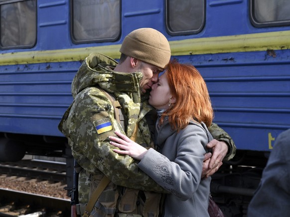A couple embrace prior to the woman boarding a train carriage leaving for western Ukraine, at the railway station in Kramatorsk, eastern Ukraine, Sunday, Feb. 27, 2022. The U.N. refugee agency says ne ...