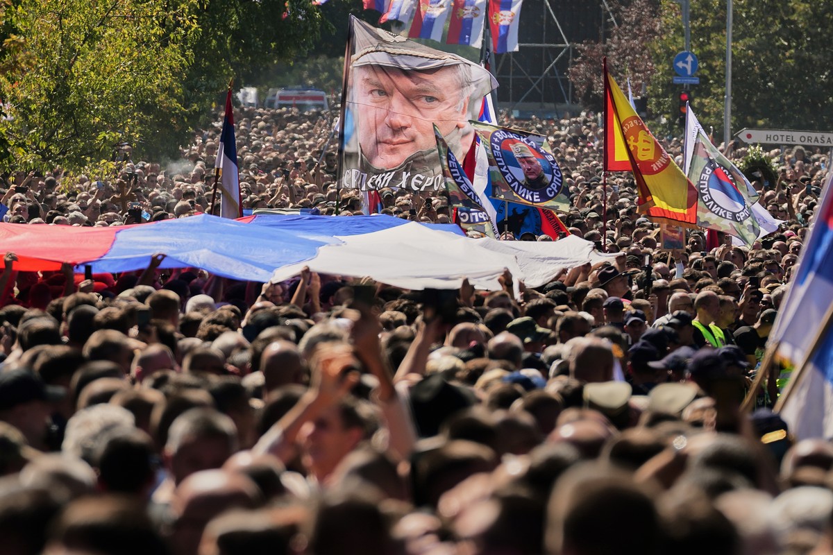 People gathered for the funeral procession wave a flag showing the former Bosnian Serb army commander Ratko Mladic, who died last week while serving a life sentence for genocide and other atrocities d ...