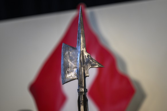 Eine Hellebarde vor einer Schweizer Flagge waehrend der Delegiertenversammlung der Schweizerischen Volkspartei SVP, fotografiert am Samstag, 25. Oktober 2025 in Wimmis. (KEYSTONE/Christian Beutler)