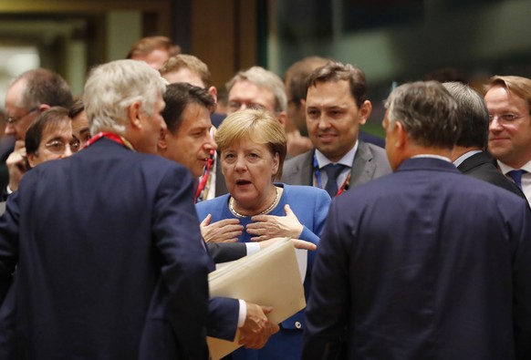 German Chancellor Angela Merkel, center, speaks with Italian Prime Minister Giuseppe Conte, center left, during a round table meeting at an EU summit in Brussels, Thursday, Oct. 17, 2019. Britain and  ...