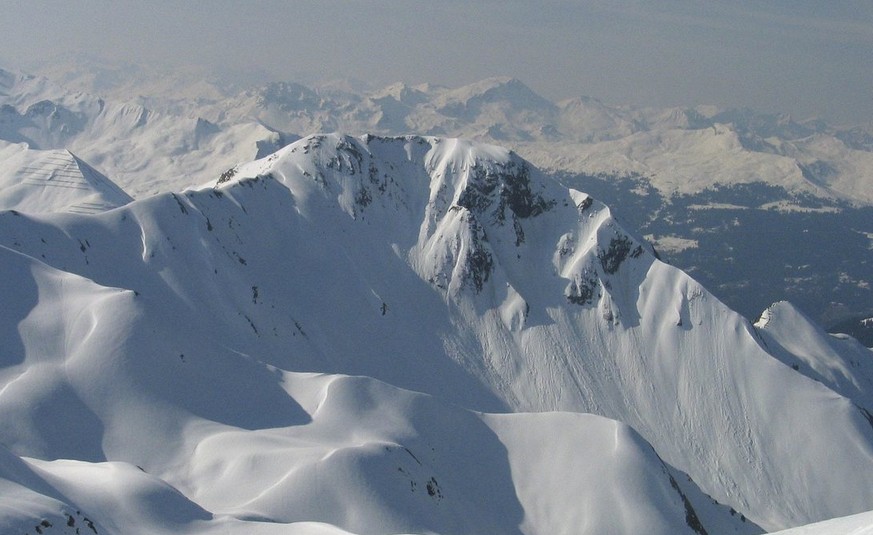 Eine Skitourengaengerin schwingt am Montag, 24. April 2006 ueber traumhafte Sulzschneehaenge vom Gipfel des 2456 Meter hohen Schafberg in St. Antoenien im Praettigau dem Tal entgegen. (KEYSTONE/Arno B ...