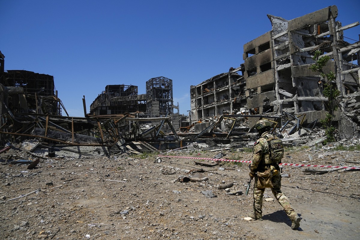 FILE - A Russian soldier walks in front of the damaged Metallurgical Combine Azovstal plant, in Mariupol, on the territory which is under the Government of the Donetsk People's Republic control,  ...