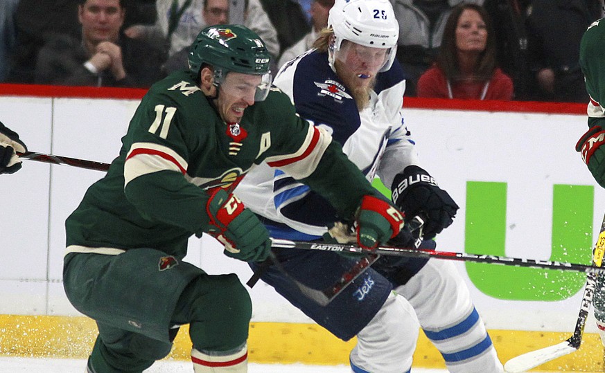 Minnesota Wild left wing Zach Parise (11) battles with Winnipeg Jets right wing Patrik Laine (29) in the first period of Game 3 of an NHL first-round hockey playoff series Sunday, April 15, 2018, in S ...