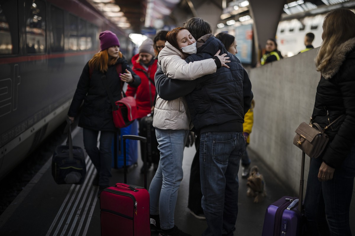 A woman from Ukraine reacts as she receives a hug after her arrival with her mother at Zurich's central station, following Russia's invasion of Ukraine, in Zurich, Switzerland on March 9, 20 ...