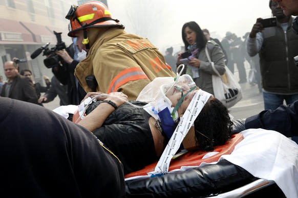 A victim is evacuated by emergency personal near an apparent building explosion fire and collapse in the Harlem section of New York City, March 12, 2014. A building collapsed in a largely residential block of Upper Manhattan on Wednesday and the New York City Fire Department was searching for anyone trapped in the debris, officials said. REUTERS/Mike Segar   (UNITED STATES - Tags: DISASTER)