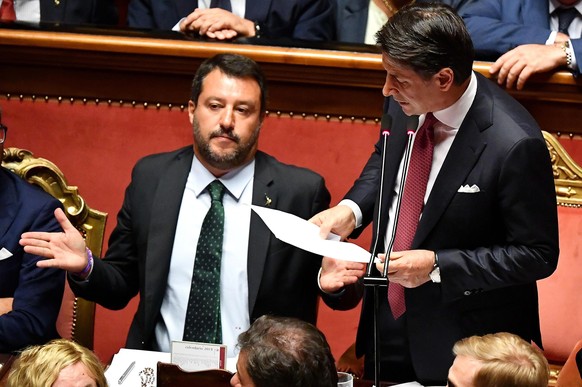 epa07782421 Italian Premier Giuseppe Conte (R) is flanked by Deputy Premier and Interior Minister Matteo Salvini (L) as he addresses the Senate over the government crisis in Rome, Italy, 20 August 201 ...