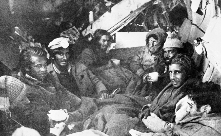 The last eight survivors of the Uruguayan Air Force plane crash in the Andes in South America, huddle together in the craft's fuselage on their final night before rescue on Dec. 22, 1972. A mountain r ...