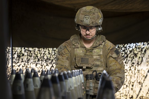 epa09361373 A handout photo made available by the Australian Department of Defence (DoD) shows Australian Army Lance Bombardier Marc Millet from the 4th Regiment, Royal Australian Artillery, preparing ...