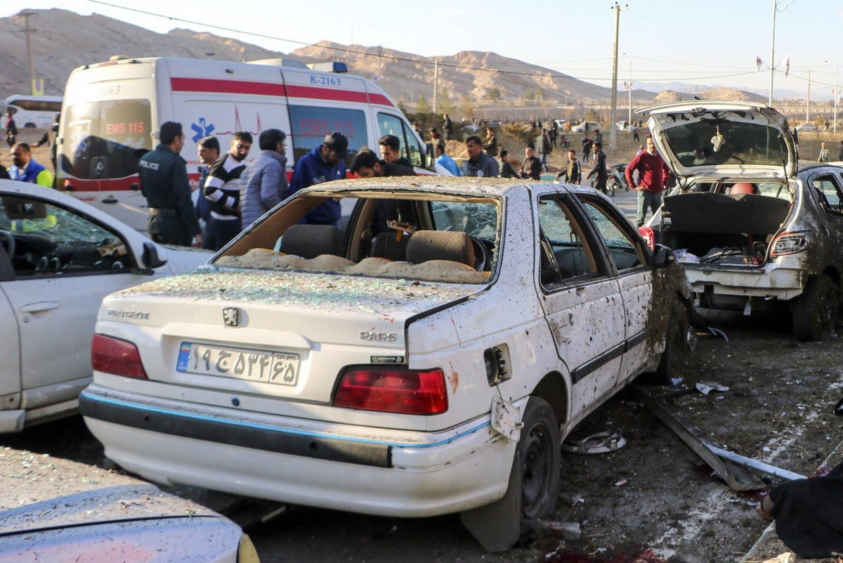 epa11055381 Damaged cars are seen as people try to help victims after an explosion next to the tomb of Iran's Revolutionary Guards chief of foreign operations in the Saheb al-Zaman mosque in the  ...