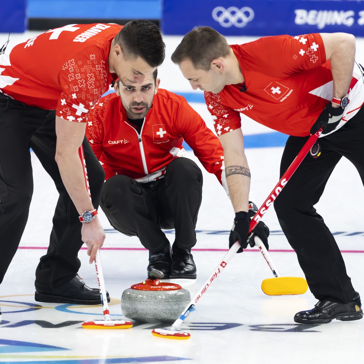 Switzerland skip Peter De Cruz, right, directs his teammates Valentin Tanner, left, and Sven Michel, right, during the men's Round Robin #3 game between Switzerland and Team ROC (Russia) at the N ...