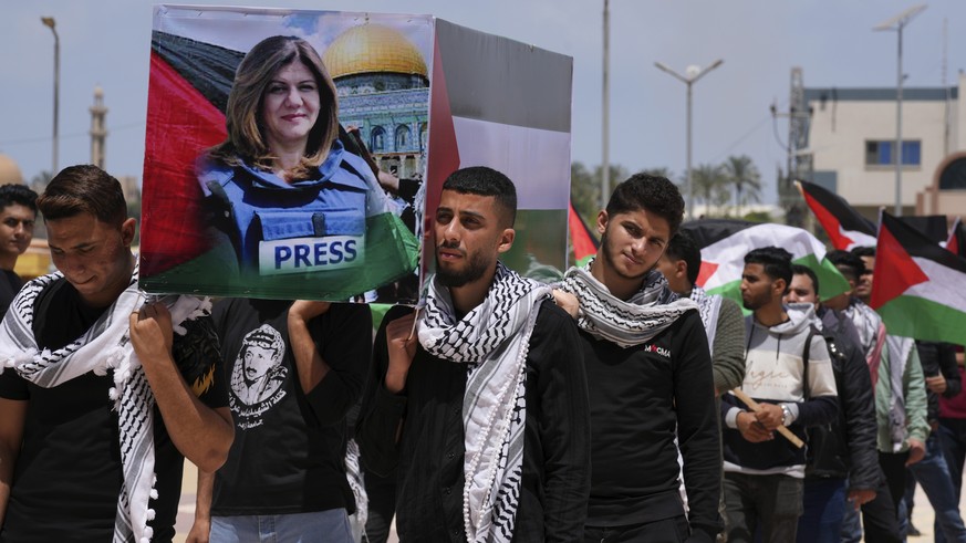 Students carry a mock coffin as they hold a symbolic funeral for slain Al Jazeera journalist Shireen Abu Akleh, at al-Azhar University in Mughraqa, central Gaza Strip, Monday, May 16, 2022. Abu Akleh  ...