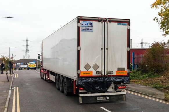 epa07943546 Police drive the lorry container along the road from the scene in Waterglade Industrial Park in Grays, Essex, Britain, 23 October 2019. A total of 39 bodies were discovered inside a lorry  ...