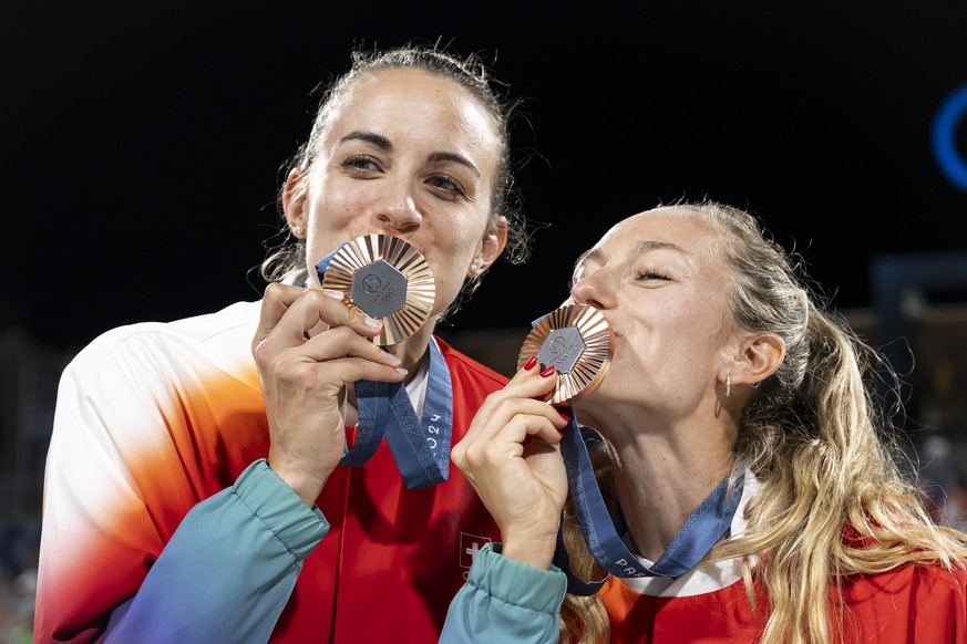Bronze medallists Tanja Hueberli, left, and Nina Brunner, right, of Switzerland, pose for photographers during the medal ceremony after the women&#039;s beach volleyball bronze medal game against Mari ...