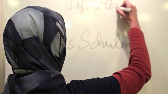 Lehrerin mit Kopftuch in einer deutschen Schule gestelltes Foto. Im sogenannten Kopftuchurteil des Bundesverfassungsgerichtes vom 24. September 2003 gaben die obersten Richter vor zehn Jahren der musl ...