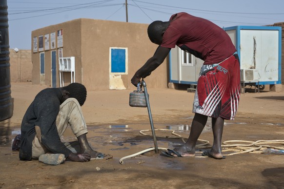 A migrant who was expelled from Algeria sits by a water point in a transit center in Arlit, Niger on Friday, June 1, 2018. With scars on his hands and arms, some assume he endured the unspeakable in A ...