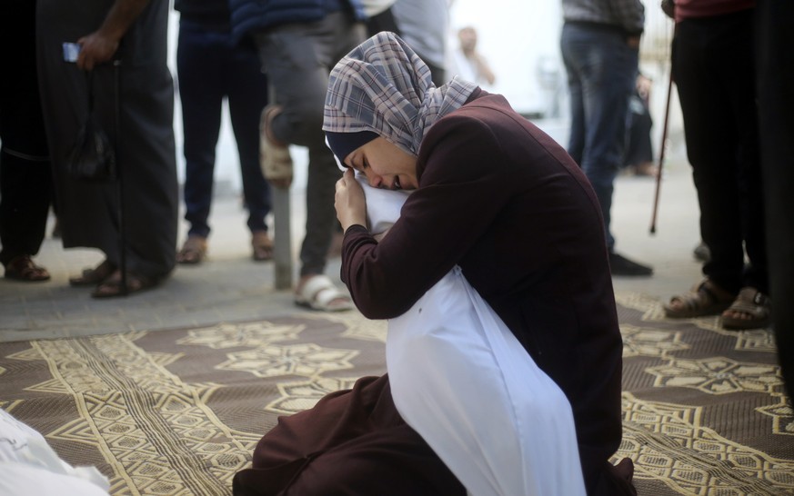 A Palestinian woman holds her cousin killed in the Israeli bombardment of the Gaza Strip in Rafah on Saturday, Oct. 21, 2023. (AP Photo/Hatem Ali)