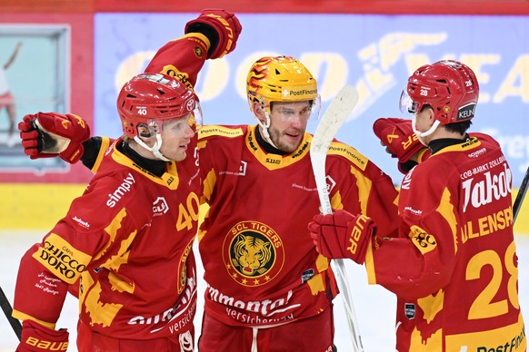 Tigers Flavio Schmutz, Postfinance Topscorer Aleski Saarela, Dario Allenspach, von links, jubeln beim 2:0 im Kampf um den Puck gegen $b beim Eishockey-Qualifikationsspiel der National League zwischen  ...