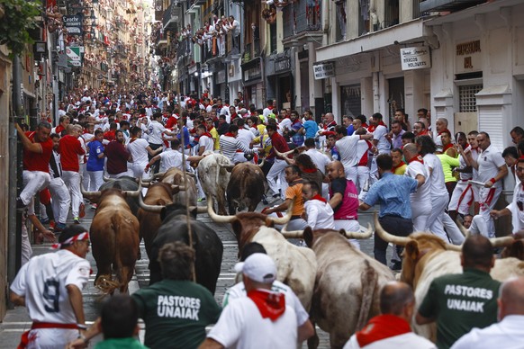 epa10069932 People take part in the traditional running of the bulls during the San Fermin Festival in Pamplona, Navarra, Spain, 14 July 2022. Pamplona&#039;s Running of the Bulls, known locally as Sa ...