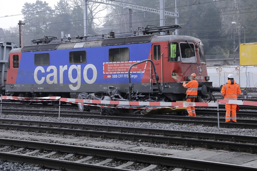 Bahnarbeiter stehen neben einer verunfallten Lokomotive und einem Baustellenfahrzeug beim Bahnhof Winterthur, am Dienstag, 7. Februar 2017. Bei der Kollision mit einem Gueterzug im Bahnhof Winterthur  ...