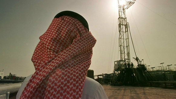 FILE - In this Feb. 26, 1997 file photo, Khaled al-Otaiby, an official of the Saudi oil company Aramco, watches progress at a rig at the al-Howta oil field near Howta, Saudi Arabia. According to an as ...