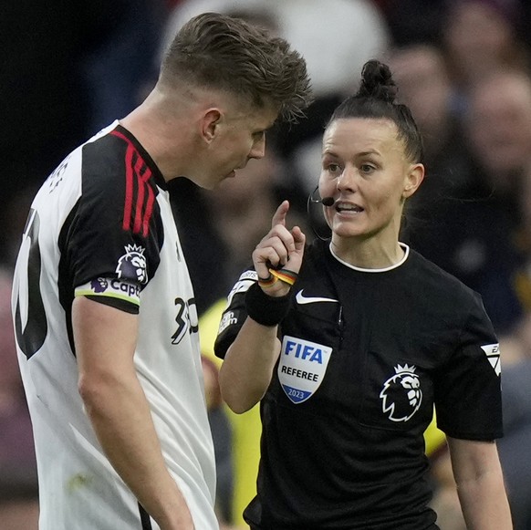Referee Rebecca Welch holds a yellow card and speaks to Fulham&#039;s team captain Tom Cairney, before showing the card to Fulham&#039;s Calvin Bassey, during the English Premier League soccer match b ...