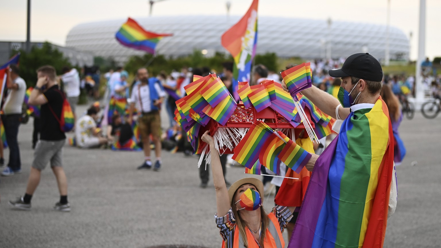 epa09296425 People prepare rainbow flags to hand out in front of the Allianz Arena stadium in Munich, Germany, 23 June 2021. The UEFA on 22 June turned down a request by the city of Munich to illumina ...
