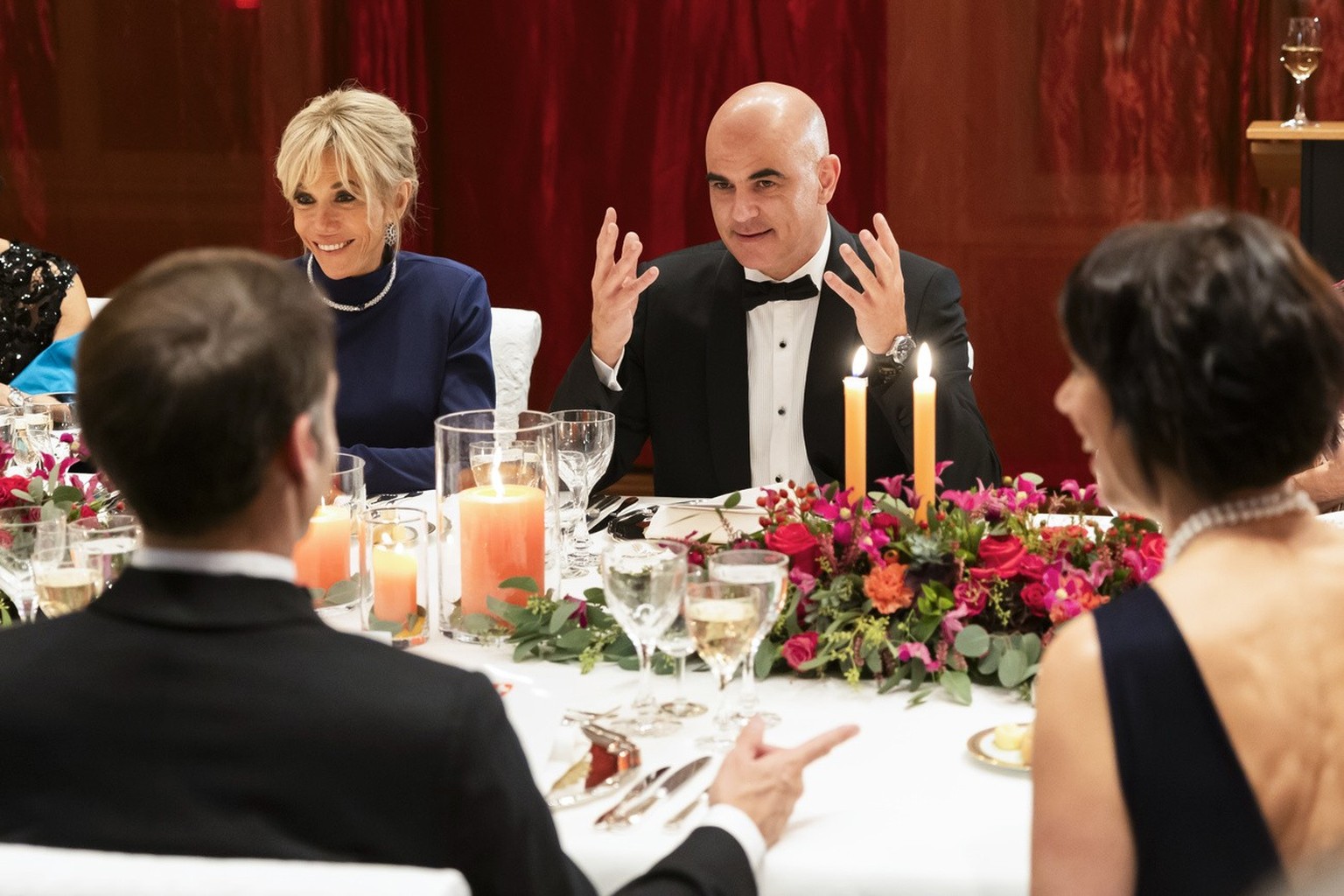 Swiss Federal President Alain Berset, back right, French President Emanuel Macron, front left, Brigitte Macron, back left, and Muriel Zeender Berset, front right, discuss at the state dinner hosted in ...