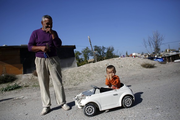 Ein Verwandter fährt mit einem Kind spazieren – Elendsviertel ausserhalb von Madrid.