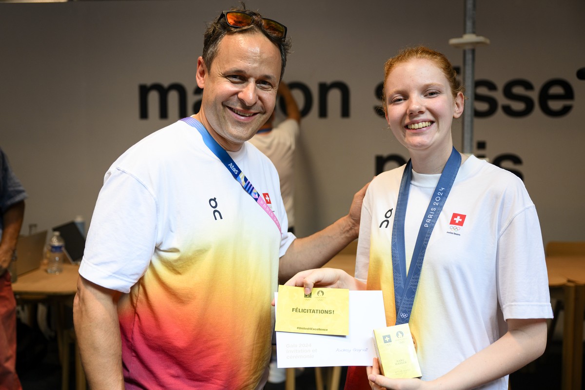 Audrey Gogniat, right, of Switzerland bronze medal winner in the women's 10m air rifle competition poses with Swiss Olympic Chef de Mission Ralph Stoeckli, left, at the reception in the maison su ...
