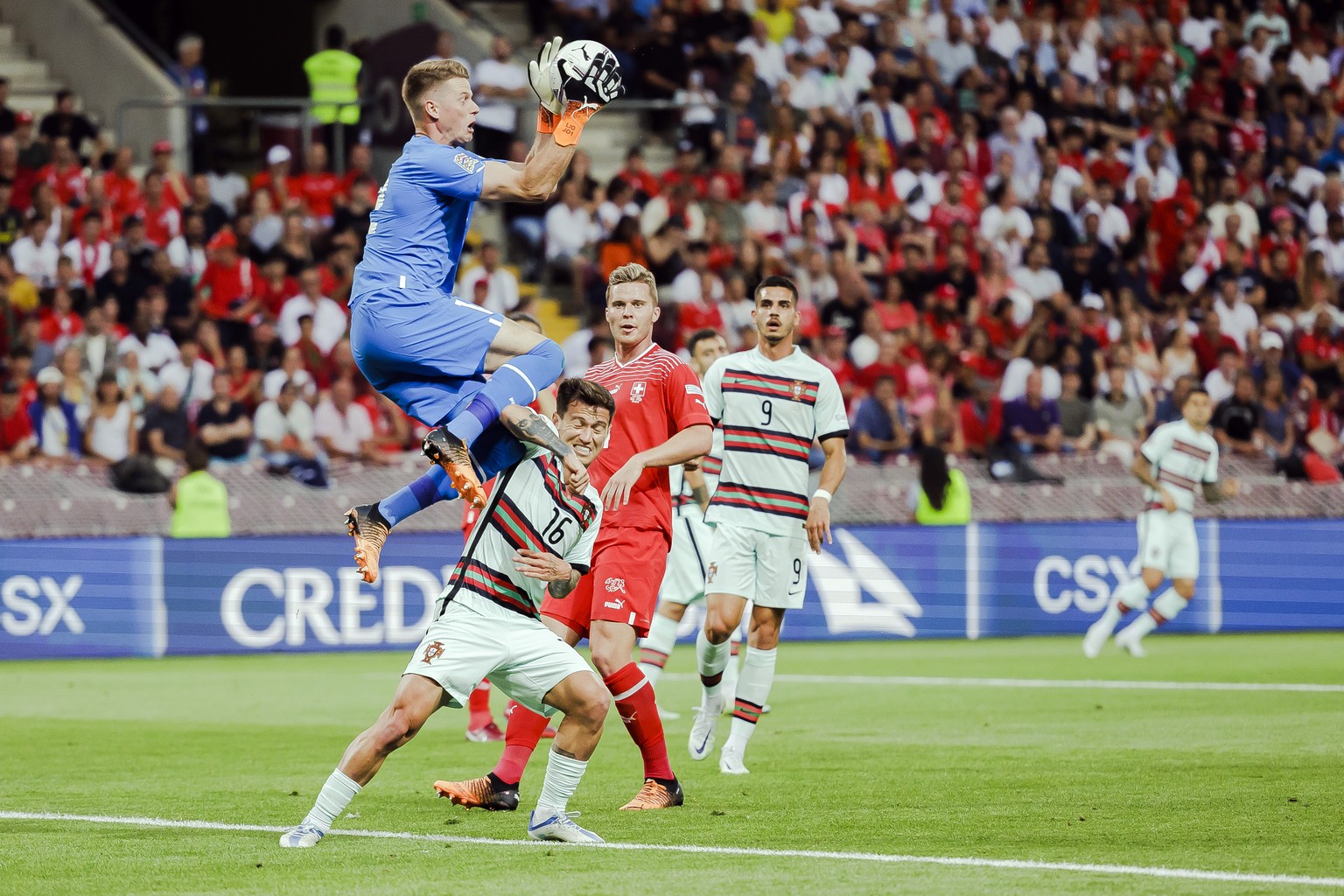 Switzerland&#039;s goalkeeper Jonas Omlin, left, makes a save against Portugal&#039;s midfielder Otavio, center, during the UEFA Nations League group A2 soccer match between Switzerland and Portugal a ...