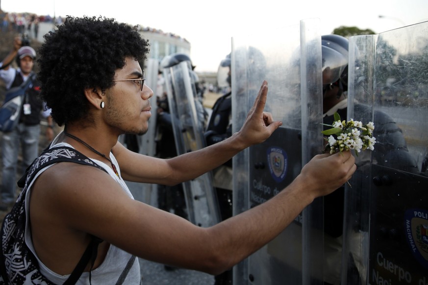 Ein Demonstrant versucht, mit Blumen die Polizisten aufzuhalten.&nbsp;