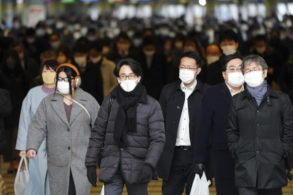 People commute on the first business day of the year near a train station Monday, Jan. 4, 2021, in Tokyo. (AP Photo/Eugene Hoshiko)