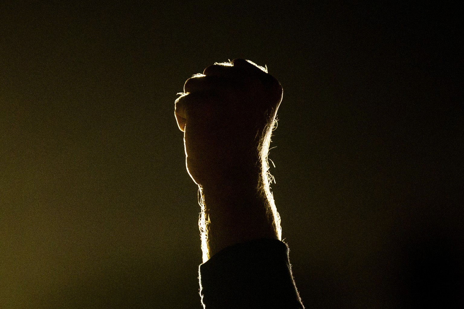 epa08638422 A protester raises his fist as people gather next to the crime scene where a black man, identified by Black Lives Matter Los Angeles as Dijon Kizzee, was shot by two sheriff deputies in We ...