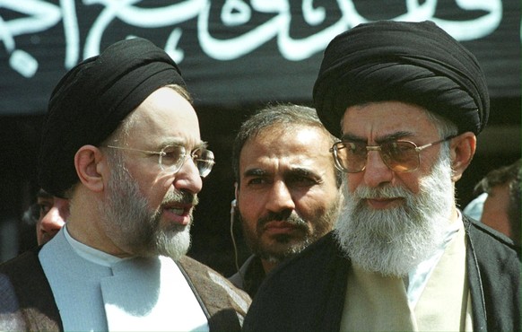 Iranian President Mohammad Khatami and Iranian supreme leader Ayatollah Ali Khamenei stand 20 May 2001 in front of parliament building in Tehran during the funeral of passengers killed onboard the Sov ...