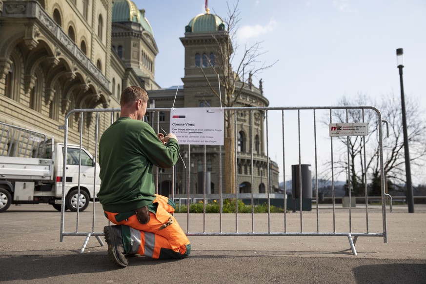 Ein Mitarbeiter der Stadt Bern bringt einen Hinweis bei einem Gitter an, dass die Bundesterrasse bis auf Weiteres geschlossen bleibt, am Freitag, 20. Maerz 2020 in Bern. Das Durchqueren der Anlage ist ...