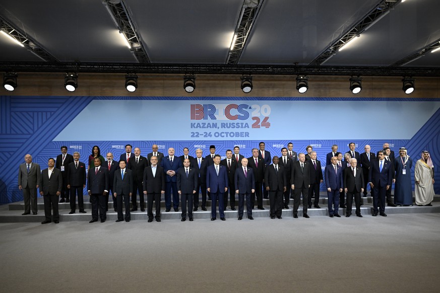 epa11679405 Russian President Vladimir Putin and participants in the outreach/BRICS Plus format meeting pose for a family photo during the BRICS summit in Kazan, Russia, 24 October 2024. The BRICS sum ...