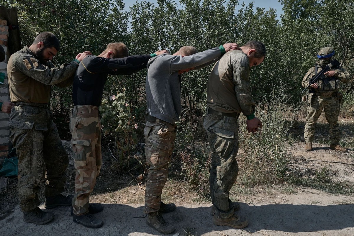 Un soldat ukrainien emmène des prisonniers de guerre russes qui se sont rendus lors des récents combats au nord de Pokrovsk.