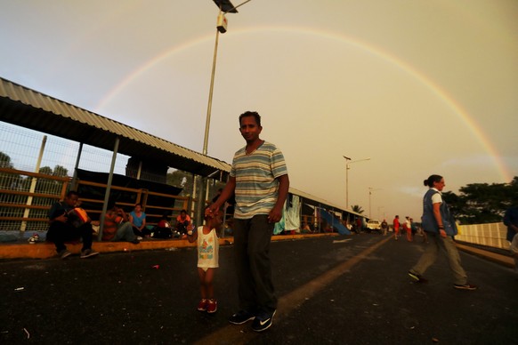 epa07110454 Honduran migrants wait at the border bridge between Guatemala and Mexico in Tecun Uman, Guatemala, 21 October 2018. Around 200 Honduran migrants spent the night on the bridge between Guate ...