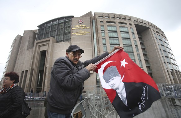 A supporter of the main opposition Republican People&#039;s Party, or CHP, holding a flag of modern Turkey&#039;s founder Mustafa Kemal Ataturk, participates in a protest outside Istanbul&#039;s Court ...