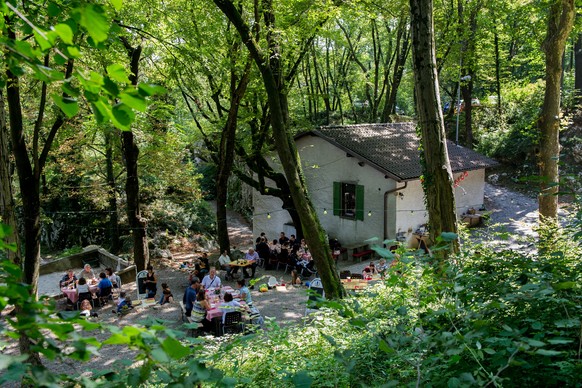 Gaeste sitzen mitten in einem Kastanien- und Lindenwald im Aussenbereich des typischen Tessiner &quot;Grotto Grassi&quot; am Samstag, 13. August 2016, in Tremona. Das Grotto Grassi wurde gegen Ende 18 ...