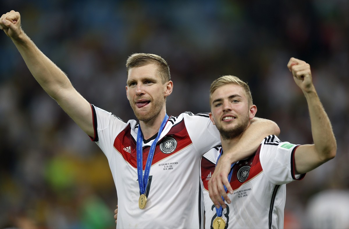 Germany's Per Mertesacker, left, and teammate Christoph Kramer celebrate after the World Cup final soccer match between Germany and Argentina at the Maracana Stadium in Rio de Janeiro, Brazil, Su ...