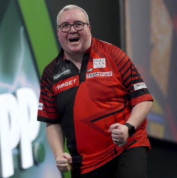 Stephen Bunting celebrates winning his match against Madars Razma on day ten of the Paddy Power World Darts Championship at Alexandra Palace, London, Friday, Dec. 27, 2024. (Bradley Collyer/PA via AP)