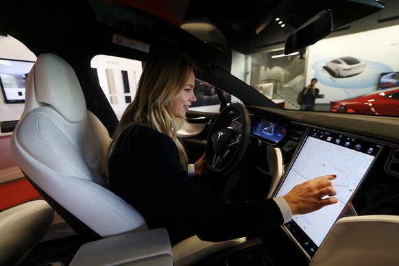 epa06213335 A woman tests a Tesla model&#039;s touchscreen display during the inauguration of US automaker Tesla&#039;s first official dealer in Spain, in L&#039;Hospitalet de Llobregat, near Barcelon ...